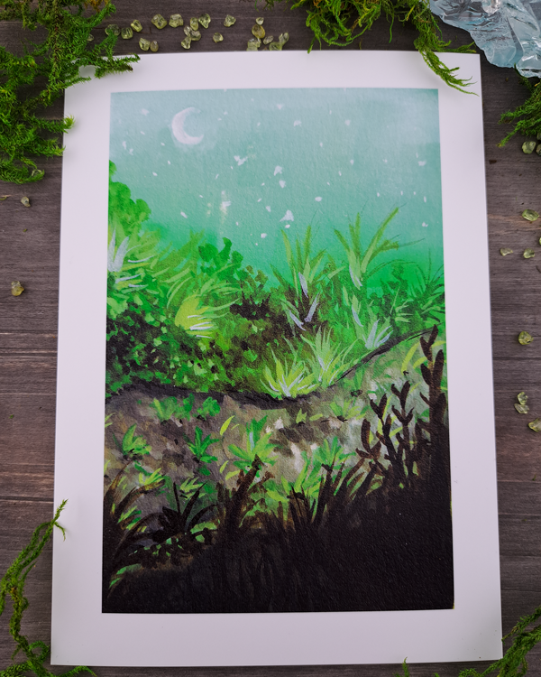 An image of a 5"x7" mini print surrounded by crystals and moss. The mini print features a vertical landscape with foliage along a pathway with a white moon shown in the pale blue sky, which was painted with acrylic inks.